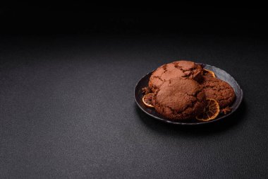 Koyu beton arka planda tatlı, gevrek çikolatalı kurabiyeler.