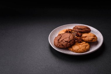 Koyu beton arka planda tatlı, gevrek çikolatalı kurabiyeler.