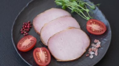 Et, tütsülenmiş, tuz, baharat ve otlarla dilimlenmiş koyu beton arka planda jambon.