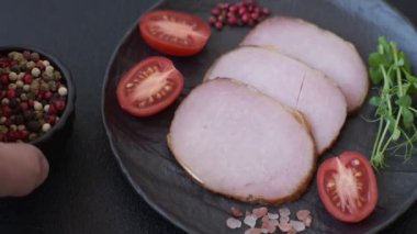 Et, tütsülenmiş, tuz, baharat ve otlarla dilimlenmiş koyu beton arka planda jambon.