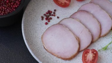 Et, tütsülenmiş, tuz, baharat ve otlarla dilimlenmiş koyu beton arka planda jambon.