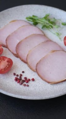 Et, tütsülenmiş, tuz, baharat ve otlarla dilimlenmiş koyu beton arka planda jambon.