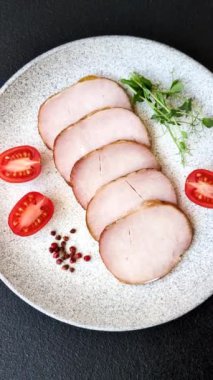 Et, tütsülenmiş, tuz, baharat ve otlarla dilimlenmiş koyu beton arka planda jambon.