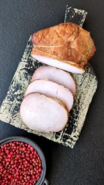 Et, tütsülenmiş, tuz, baharat ve otlarla dilimlenmiş koyu beton arka planda jambon.