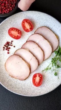 Et, tütsülenmiş, tuz, baharat ve otlarla dilimlenmiş koyu beton arka planda jambon.