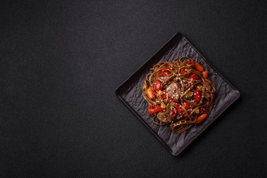 Lezzetli baharatlı Asya yemeği sobası karabuğday eriştesi, sığır eti, sebze, tuz ve baharat.