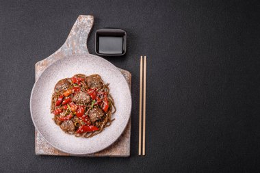 Lezzetli baharatlı Asya yemeği sobası karabuğday eriştesi, sığır eti, sebze, tuz ve baharat.