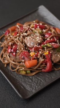 Lezzetli baharatlı Asya yemeği sobası karabuğday eriştesi, sığır eti, sebze, tuz ve baharat.