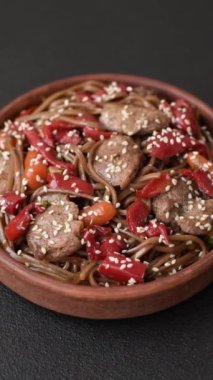 Lezzetli baharatlı Asya yemeği sobası karabuğday eriştesi, sığır eti, sebze, tuz ve baharat.