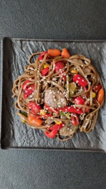 Lezzetli baharatlı Asya yemeği sobası karabuğday eriştesi, sığır eti, sebze, tuz ve baharat.