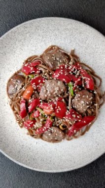 Lezzetli baharatlı Asya yemeği sobası karabuğday eriştesi, sığır eti, sebze, tuz ve baharat.