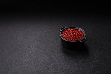 Baharat, tüm bezelyeler kırmızı ya da pembe renkli siyah beton arka planda bir kasede. Asya mutfağı