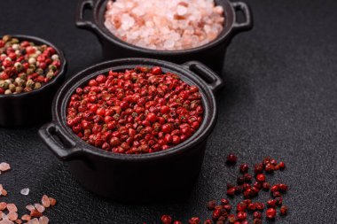 Baharat, tüm bezelyeler kırmızı ya da pembe renkli siyah beton arka planda bir kasede. Asya mutfağı