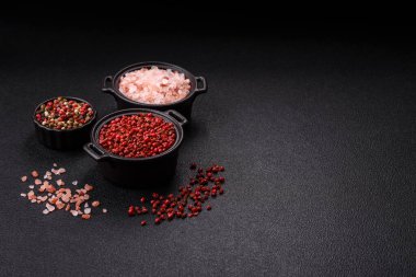Baharat, tüm bezelyeler kırmızı ya da pembe renkli siyah beton arka planda bir kasede. Asya mutfağı