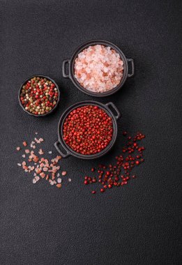 Baharat, tüm bezelyeler kırmızı ya da pembe renkli siyah beton arka planda bir kasede. Asya mutfağı