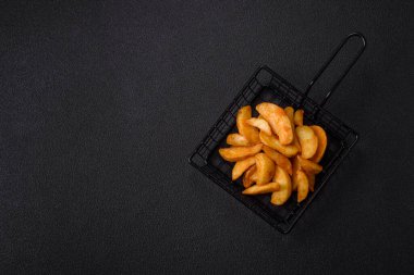 Koyu arkaplanda peynirli ve otlu fırında patates dilimleri. Ev yapımı organik sebze vejetaryen patates dilimleri.