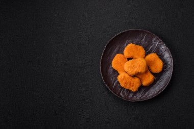Delicious fresh crispy chicken nuggets on a dark concrete background. Unhealthy food, fast food