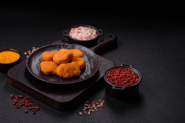 Delicious fresh crispy chicken nuggets on a dark concrete background. Unhealthy food, fast food