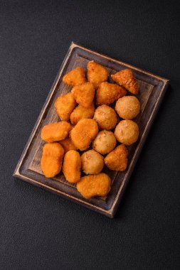 Fast food brie kızartması, peynir topları ve arka planda tavuk nuggetları.