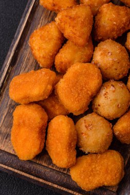 Fast food brie kızartması, peynir topları ve arka planda tavuk nuggetları.