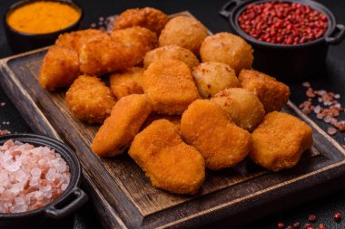 Fast food brie kızartması, peynir topları ve arka planda tavuk nuggetları.