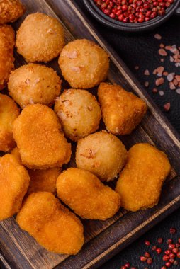 Fast food brie kızartması, peynir topları ve arka planda tavuk nuggetları.