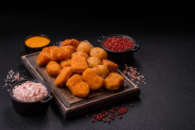 Fast food brie kızartması, peynir topları ve arka planda tavuk nuggetları.