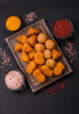 Fast food brie kızartması, peynir topları ve arka planda tavuk nuggetları.