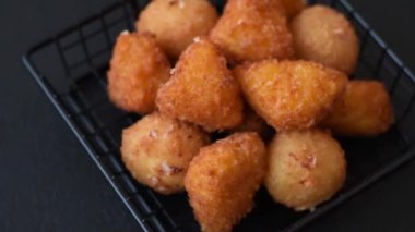 Fast food brie kızartması, peynir topları ve arka planda tavuk nuggetları.