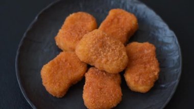 Delicious fresh crispy chicken nuggets on a dark concrete background. Unhealthy food, fast food
