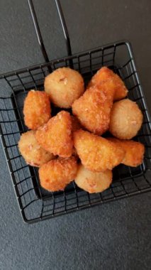 Fast food brie kızartması, peynir topları ve arka planda tavuk nuggetları.