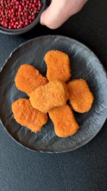 Delicious fresh crispy chicken nuggets on a dark concrete background. Unhealthy food, fast food