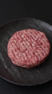 Beton kaplamalı tuzlu ve baharatlı taze çiğ biftek köftesi.