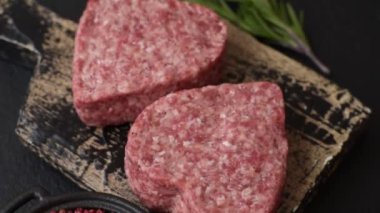 Tuzlu, baharatlı ve otlu kalp şeklinde çiğ biftek veya domuz burger köftesi.