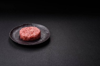 Beton kaplamalı tuzlu ve baharatlı taze çiğ biftek köftesi.