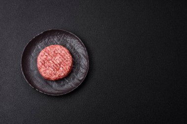 Beton kaplamalı tuzlu ve baharatlı taze çiğ biftek köftesi.