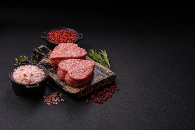 Tuzlu, baharatlı ve otlu kalp şeklinde çiğ biftek veya domuz burger köftesi.