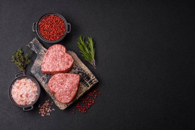 Tuzlu, baharatlı ve otlu kalp şeklinde çiğ biftek veya domuz burger köftesi.
