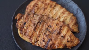 Lezzetli taze ızgara tavuk filetosu, esrarlı baharatlar ve çimento kaplı otlar. Ateşte pişirilmiş bir tabak.