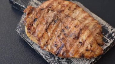 Lezzetli taze ızgara tavuk filetosu, esrarlı baharatlar ve çimento kaplı otlar. Ateşte pişirilmiş bir tabak.