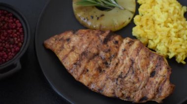 Lezzetli taze ızgara tavuk filetosu, esrarlı baharatlar ve çimento kaplı otlar. Ateşte pişirilmiş bir tabak.