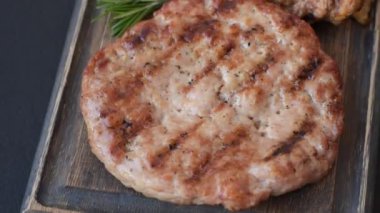 Lezzetli taze ızgara hindi filetosu, koyu beton arka planda baharatlar ve otlar. Ateşte pişirilmiş bir tabak.