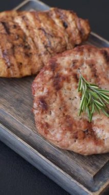 Lezzetli taze ızgara hindi filetosu, koyu beton arka planda baharatlar ve otlar. Ateşte pişirilmiş bir tabak.