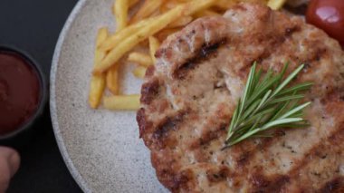 Lezzetli taze ızgara hindi filetosu, koyu beton arka planda baharatlar ve otlar. Ateşte pişirilmiş bir tabak.