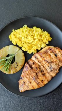 Lezzetli taze ızgara tavuk filetosu, esrarlı baharatlar ve çimento kaplı otlar. Ateşte pişirilmiş bir tabak.