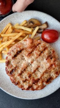 Lezzetli taze ızgara hindi filetosu, koyu beton arka planda baharatlar ve otlar. Ateşte pişirilmiş bir tabak.