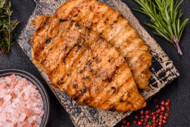 Lezzetli taze ızgara tavuk filetosu, esrarlı baharatlar ve çimento kaplı otlar. Ateşte pişirilmiş bir tabak.