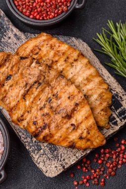 Lezzetli taze ızgara tavuk filetosu, esrarlı baharatlar ve çimento kaplı otlar. Ateşte pişirilmiş bir tabak.