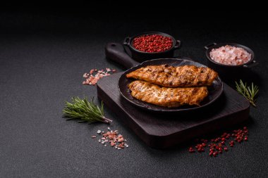 Lezzetli taze ızgara tavuk filetosu, esrarlı baharatlar ve çimento kaplı otlar. Ateşte pişirilmiş bir tabak.