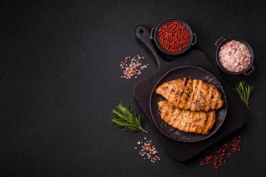 Lezzetli taze ızgara tavuk filetosu, esrarlı baharatlar ve çimento kaplı otlar. Ateşte pişirilmiş bir tabak.